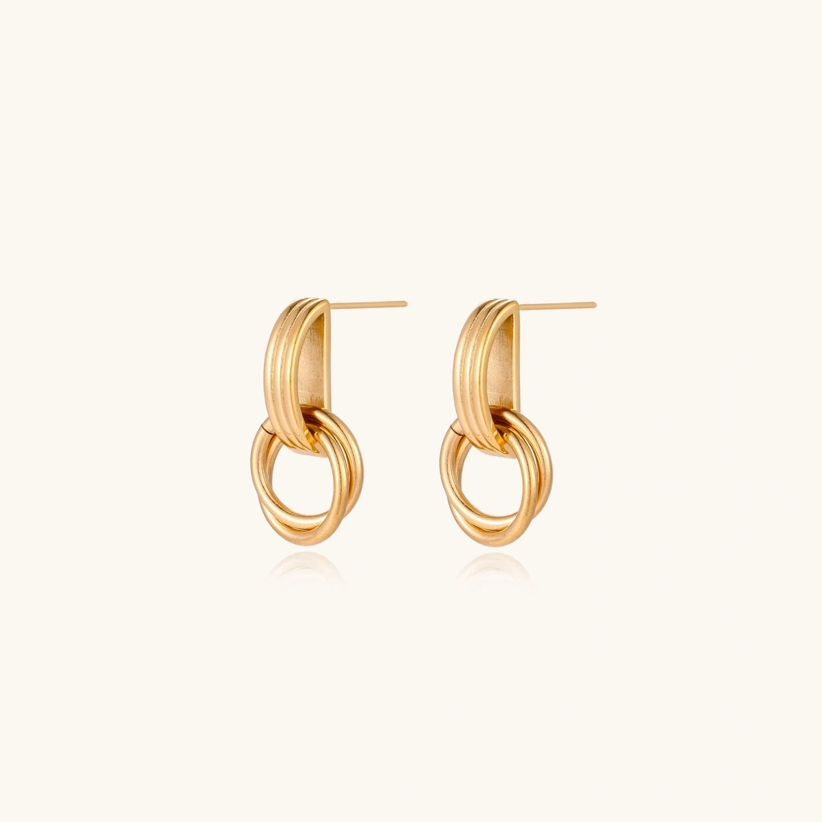 Gold stud earrings with vertical ridged bar connecting to triple interlocking circular rings on white background